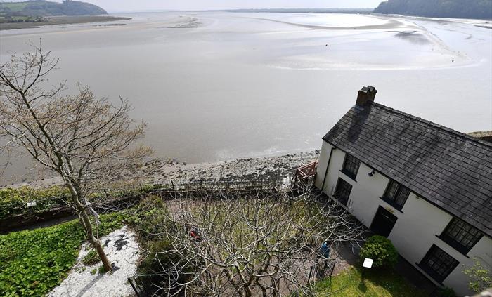looking down onto the Dylan Thomas boathouse with the estuary beyond